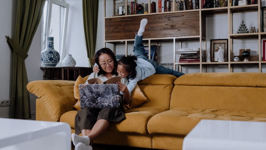 Γυναίκα μαζί με ένα κοριτσάκι επάνω σε καναπέ μέσα σε σπίτι