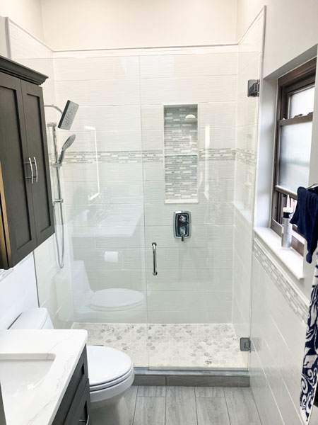 Μπάνιο με γυάλινη καμπίνα ντουζιέρας και μοντέρνα πλακάκια σε γκρι αποχρώσεις