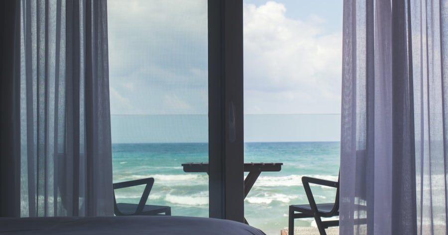 Εσωτερικός χώρος δωματίου με θέα μπαλκόνι και θάλασσα