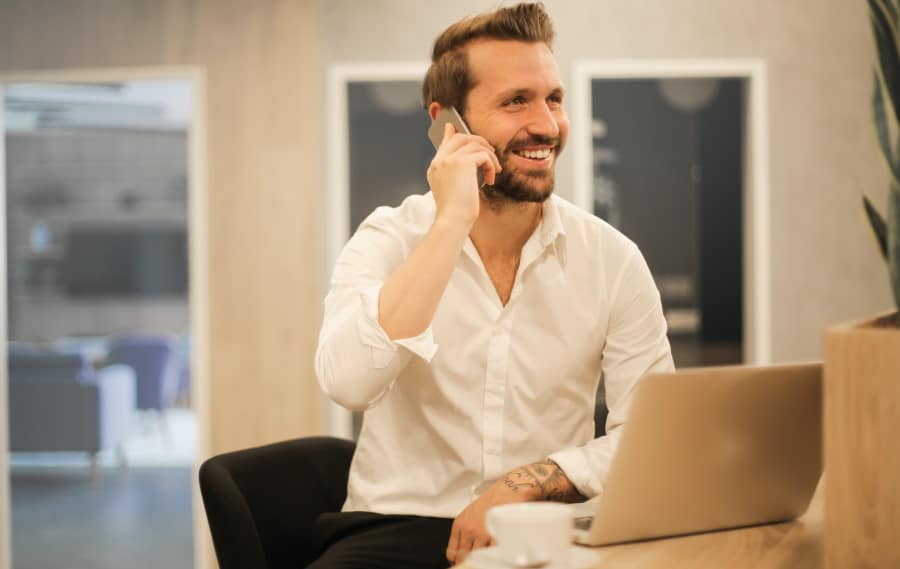 Άνδρας με λευκό πουκάμισο μιλάει στο τηλέφωνο