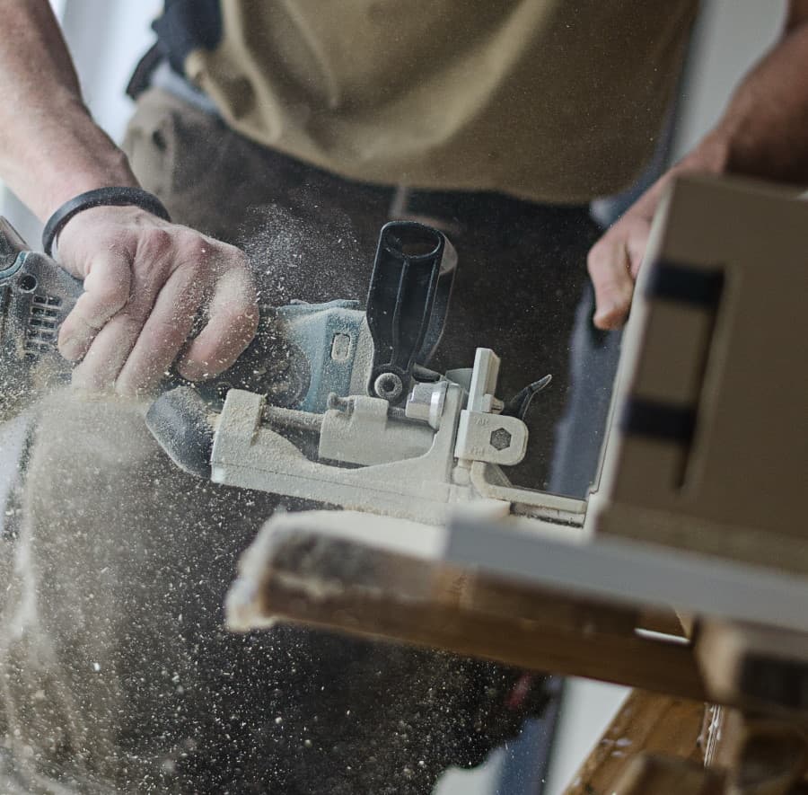 Άνδρας τρίβει ξύλινη επιφάνεια με εργαλείο