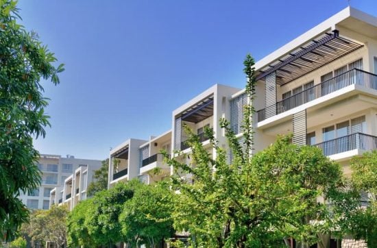 Δέντρα και μπαλκόνια διαμερισμάτων με γαλανό ουρανό