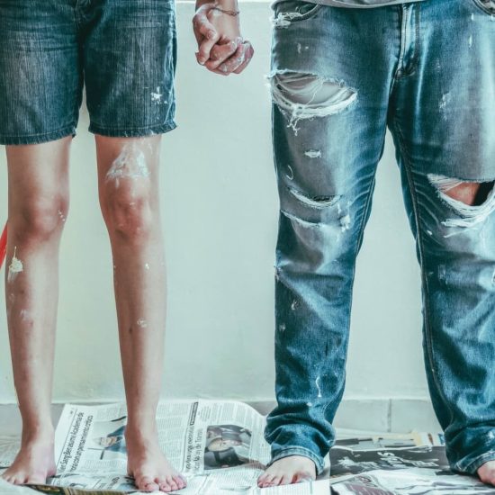 Γυναίκα και άνδρας λερωμένοι με μπογιές σε σπίτι κατά την ανακαίνιση