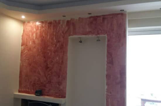 διακοσμητικός τοίχος με επένδυση πλακιδίων τύπου πέτρας γύρω από τζάκι σε ανακαίνιση σαλονιού