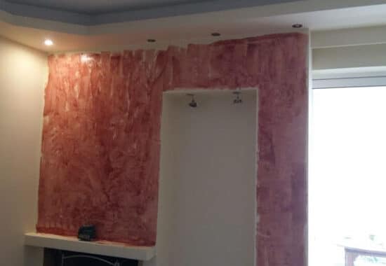 διακοσμητικός τοίχος με επένδυση πλακιδίων τύπου πέτρας γύρω από τζάκι σε ανακαίνιση σαλονιού