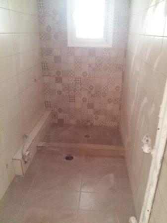 Τοποθέτηση νέων πλακιδίων μπάνιου κατά τη διάρκεια ανακαίνισης στα Πετράλωνα