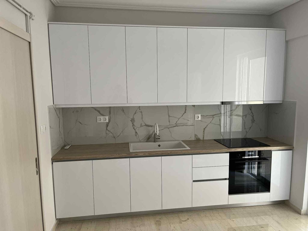 Ανακαίνιση κουζίνας στον Άλιμο με λευκά ντουλάπια, πάγκο κουζίνας και εντοιχισμένο φούρνο από την Chroma Decor