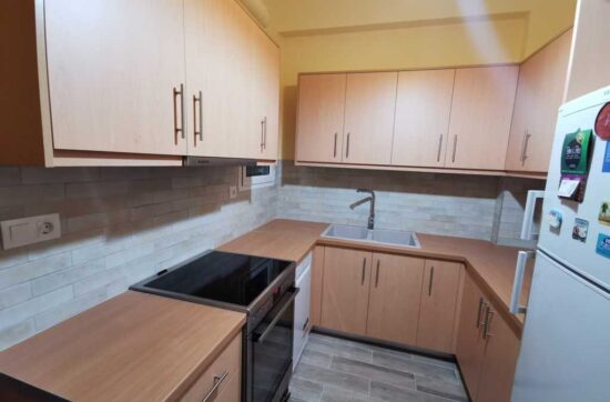 Ανακαινισμένη κουζίνα σε διαμέρισμα με νέα έπιπλα και πλακίδια τοίχου