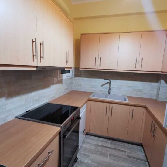 Ανακαινισμένη κουζίνα σε διαμέρισμα με νέα έπιπλα και πλακίδια τοίχου