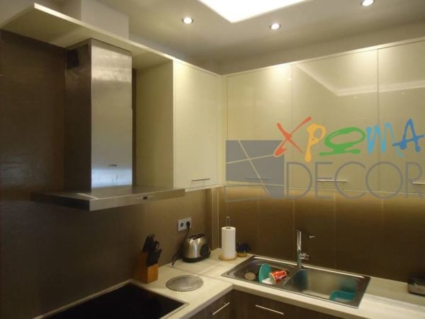 Ανακαίνιση κουζίνας στα Κάτω Πετράλωνα με λευκά επάνω ντουλάπια, λευκό πάγκο και ανοξείδωτο νεροχύτη