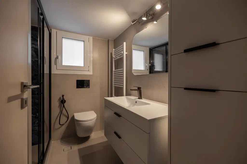 ανακαίνιση μπάνιου με κρεμαστό έπιπλο, επιτοίχια λεκάνη και λεπτομέρειες gunmetal