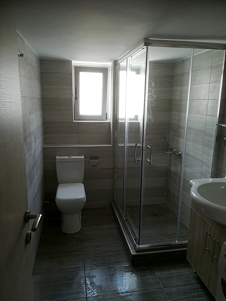 Ανακαίνιση μπάνιου στην Ηλιούπολη με καμπίνα ντουζιέρας και γκρι πλακάκια