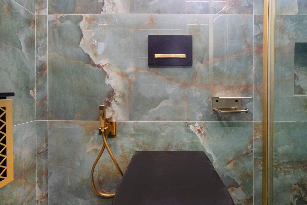 WC μπάνιου με εντοιχισμένο καζανάκι, χρυσή μπαταρία και πλακίδια μαρμάρου σε ανακαίνιση στα Πατήσια