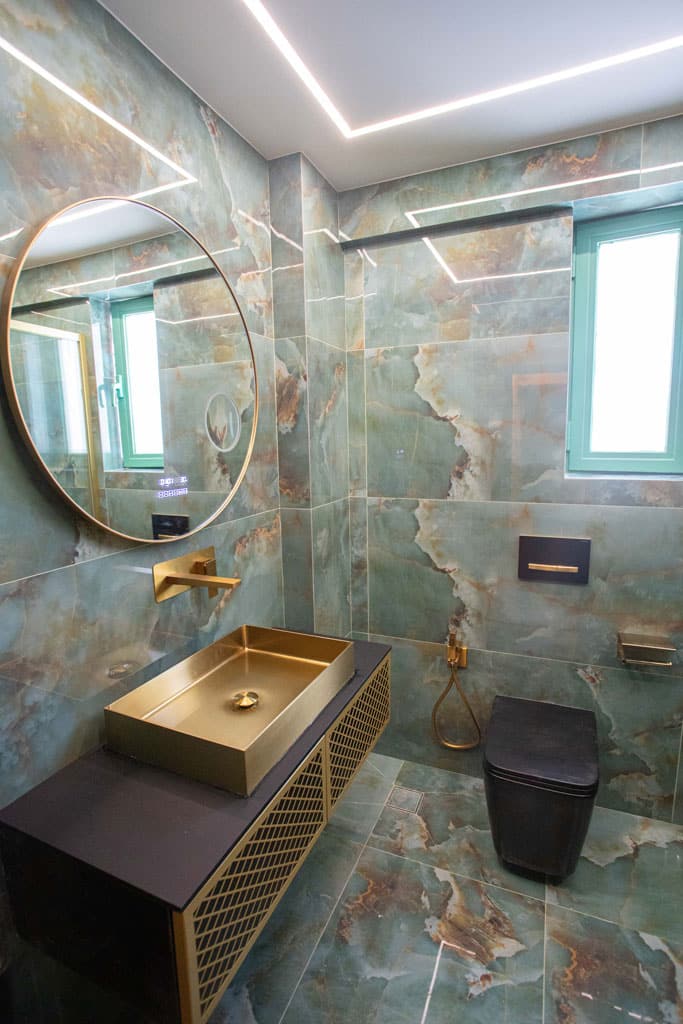 Luxury ανακαίνιση μπάνιου στα Πατήσια με χρυσό νιπτήρα, επιτοίχια μπαταρία και πλακάκια marble-look