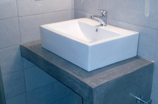 Ανακαίνιση μπάνιου στο Μεταξουργείο με minimal πλακάκια και χτιστό έπιπλο νιπτήρα