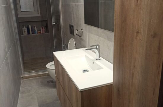 Ανακαίνιση μπάνιου στη Νίκαια με μοντέρνο έπιπλο νιπτήρα και γκρι πλακάκια