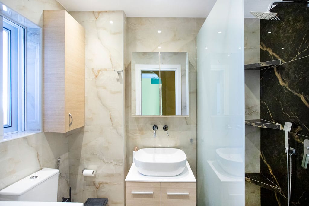 Ανακαινισμένο μπάνιο με καμπίνα ντουζιέρας και έπιπλο νιπτήρα σε διαμέρισμα στον Πειραιά