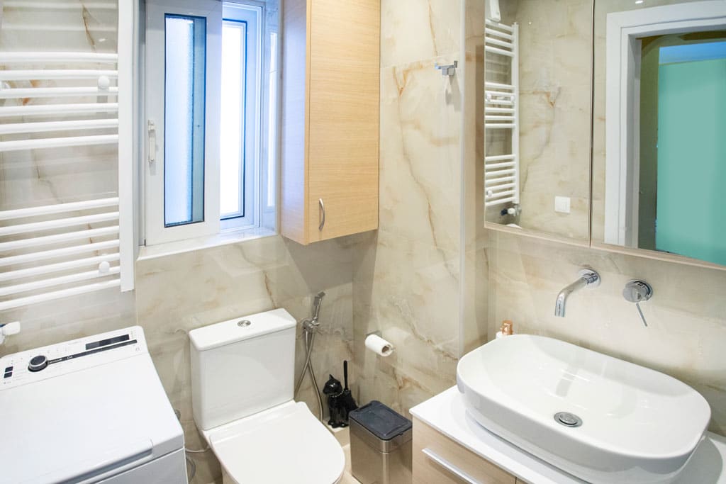 Ανακαινισμένο μπάνιο με νιπτήρα, λεκάνη και πετσετοκρεμάστρα σε διαμέρισμα στον Πειραιά