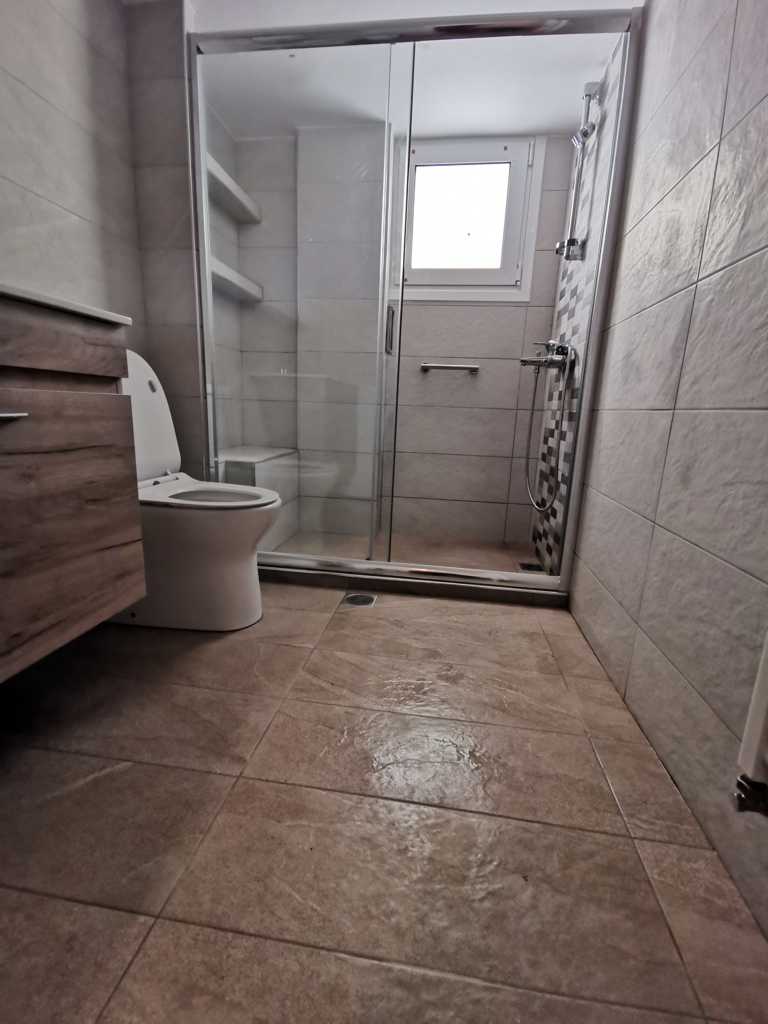 Ανακαινισμένο μικρό μπάνιο στην Καλλιθέα με καμπίνα ντουζιέρας και γκρι πλακάκια