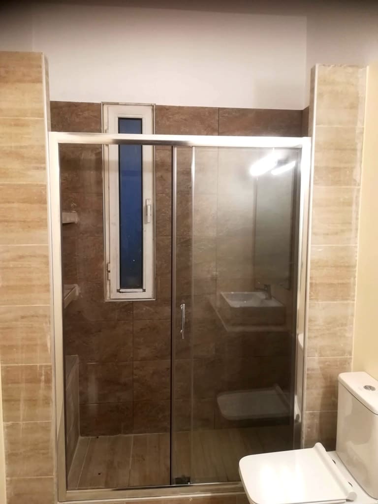 καμπίνα ντουζιέρας με συρόμενα κρύσταλλα σε ανακαινισμένο μπάνιο στον Άγιο Στέφανο