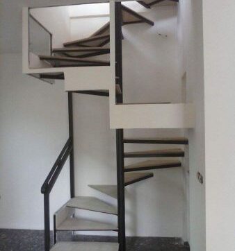 Εσωτερική μεταλλική σκάλα με μαύρο μεταλλικό σκελετό και λευκά πατήματα