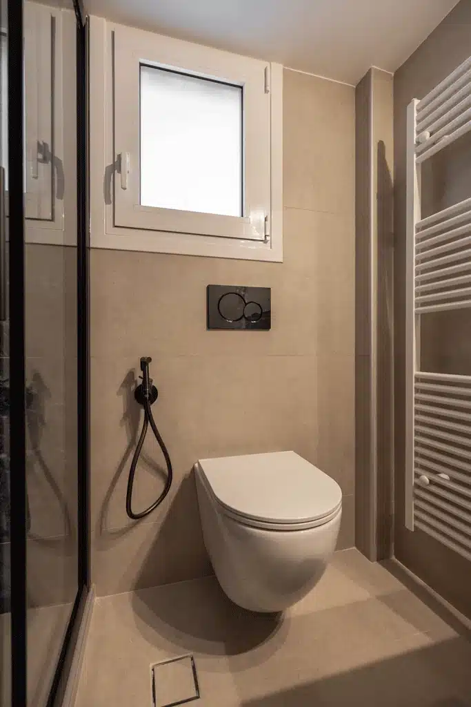 Κρεμαστή λεκάνη με εντοιχισμένο καζανάκι και βρυσάκι υγιεινής gunmetal σε μοντέρνα ανακαίνιση μπάνιου