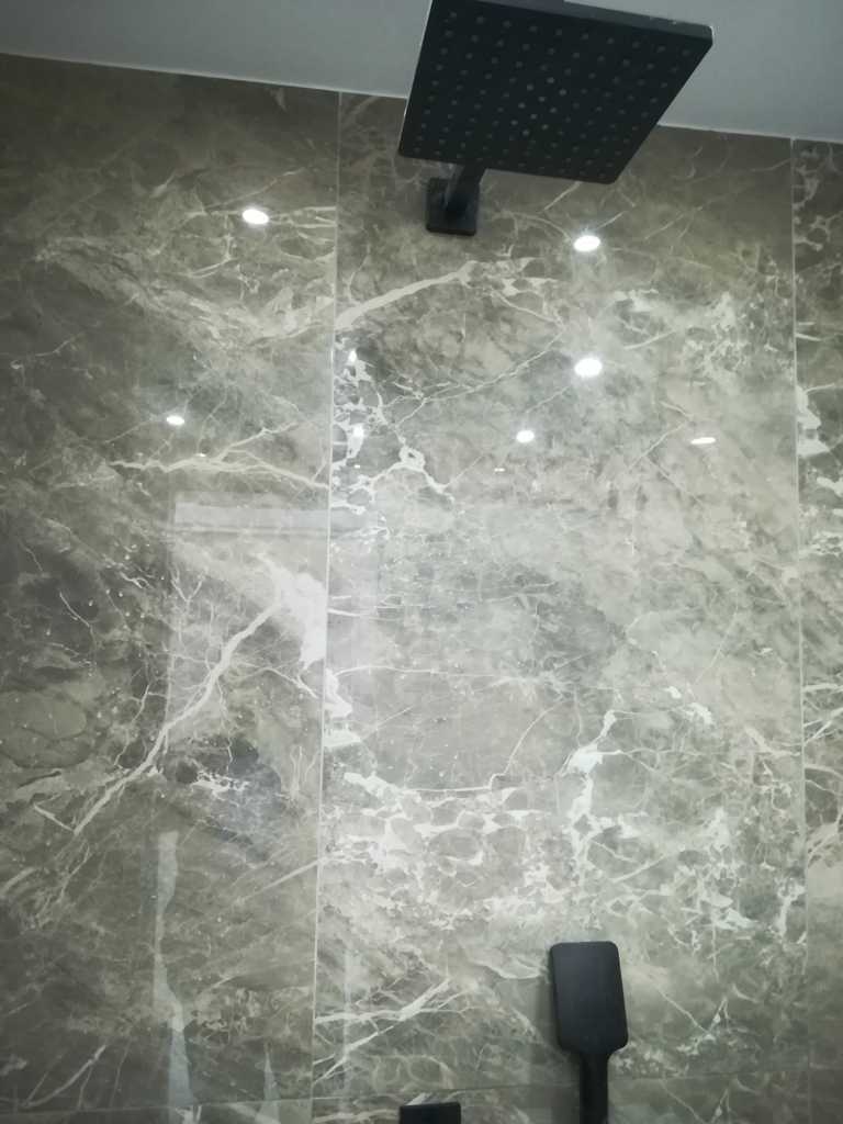 Μαύρη κεφαλή ντους οροφής (rainfall) με πλακάκια μαρμάρινης υφής σε ανακαίνιση μπάνιου στον Ταύρο