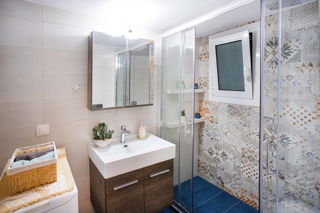 Ανακαίνιση μπάνιου στην Καλλιθέα με ρετρό πλακάκια, γυάλινη καμπίνα ντους και σύγχρονο νιπτήρα