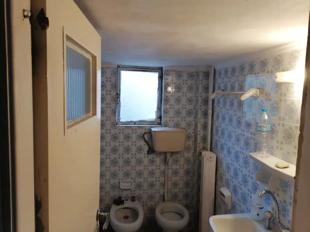 Παλιό μικρό μπάνιο πριν την ανακαίνιση με ρετρό πλακάκια, καζανάκι τοίχου και μπιντέ