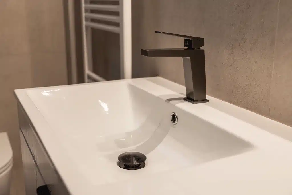 Μπαταρία νιπτήρα σε φινίρισμα gunmetal τοποθετημένη σε λευκό νιπτήρα σε μοντέρνο μπάνιο