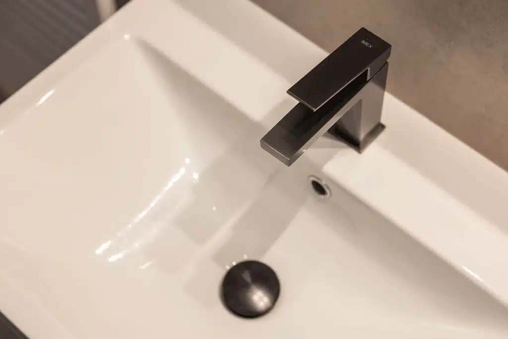 Μπαταρία νιπτήρα σε φινίρισμα gunmetal τοποθετημένη σε λευκό νιπτήρα σε σύγχρονη ανακαίνιση μπάνιου