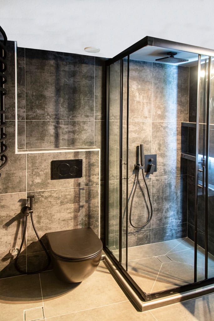 Ανακαίνιση μπάνιου στον Νέο Κόσμο με μαύρη κρεμαστή λεκάνη και walk-in ντουζιέρα σε industrial ύφος