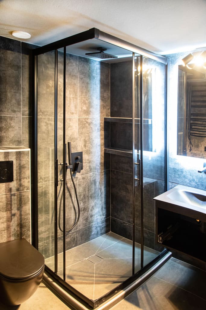 Ανακαίνιση μπάνιου στον Νέο Κόσμο με walk-in ντουζιέρα, μαύρο πλαίσιο και industrial γκρι πλακάκια