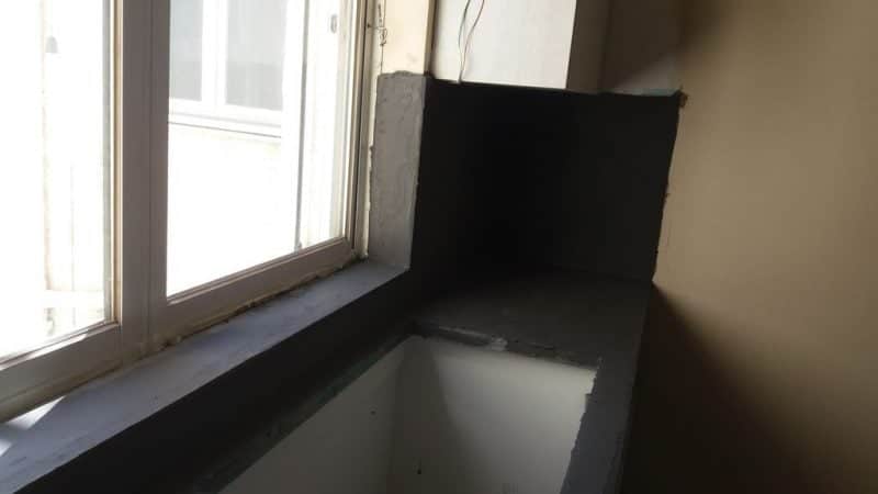 Πατητή τσιμεντοκονία σε πάγκο κουζίνας κάτω από παράθυρο με κάθετη επένδυση τοίχου