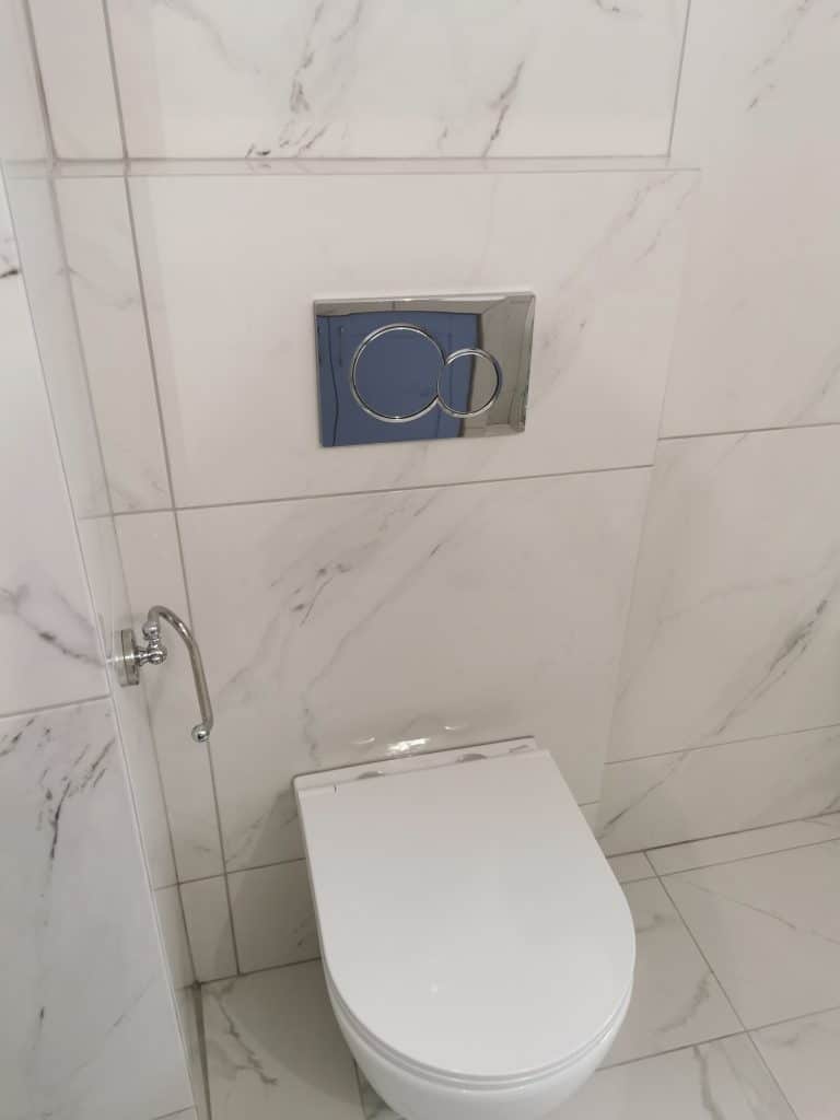 Εντοιχισμένο καζανάκι και λεκάνη σε ανακαινισμένο μπάνιο στο Παγκράτι με πλακάκια μαρμάρινης υφής