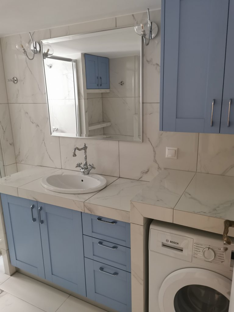Ολική ανακαίνιση μπάνιου στο Παγκράτι με μπλε έπιπλο, custom πάγκο και ενσωματωμένο πλυντήριο