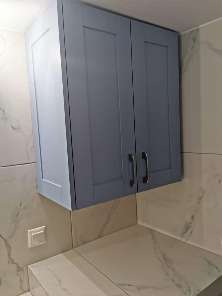 Κρεμαστό μπλε ντουλάπι σε ανακαινισμένο μπάνιο στο Παγκράτι με πλακάκια μαρμάρινης υφής