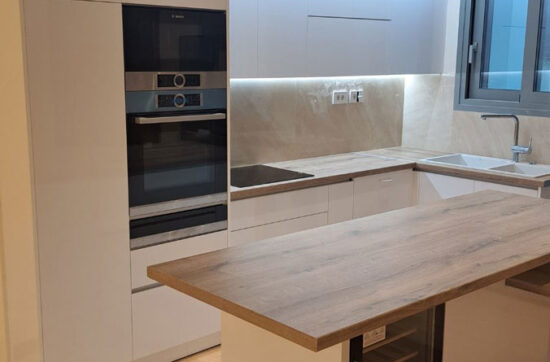 Ανακαίνιση κουζίνας στο Γκύζη με νησίδα, λευκά ντουλάπια λάκας και κρυφό LED φωτισμό από τη Chroma Decor