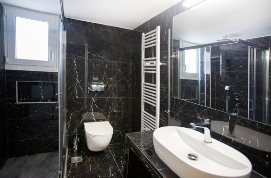 Ανακαίνιση μπάνιου στον Άλιμο με μαύρα πλακάκια τύπου μαρμάρου, κρεμαστή λεκάνη και καμπίνα ντους