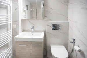 Ανακαίνιση μπάνιου στο Χαλάνδρι με κρεμαστή λεκάνη, ντουζάκι υγιεινής και κρεμ πλακάκια τύπου μαρμάρου