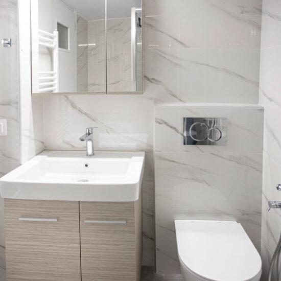 Ανακαίνιση μπάνιου στο Χαλάνδρι με κρεμαστή λεκάνη, ντουζάκι υγιεινής και κρεμ πλακάκια τύπου μαρμάρου