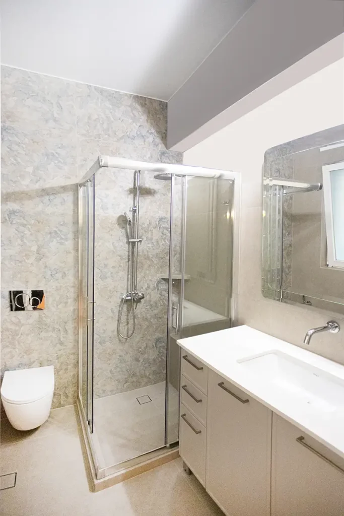 Γενική άποψη από ανακαινισμένο μπάνιο στη Γλυφάδα με ντουζιέρα και έπιπλο νιπτήρα