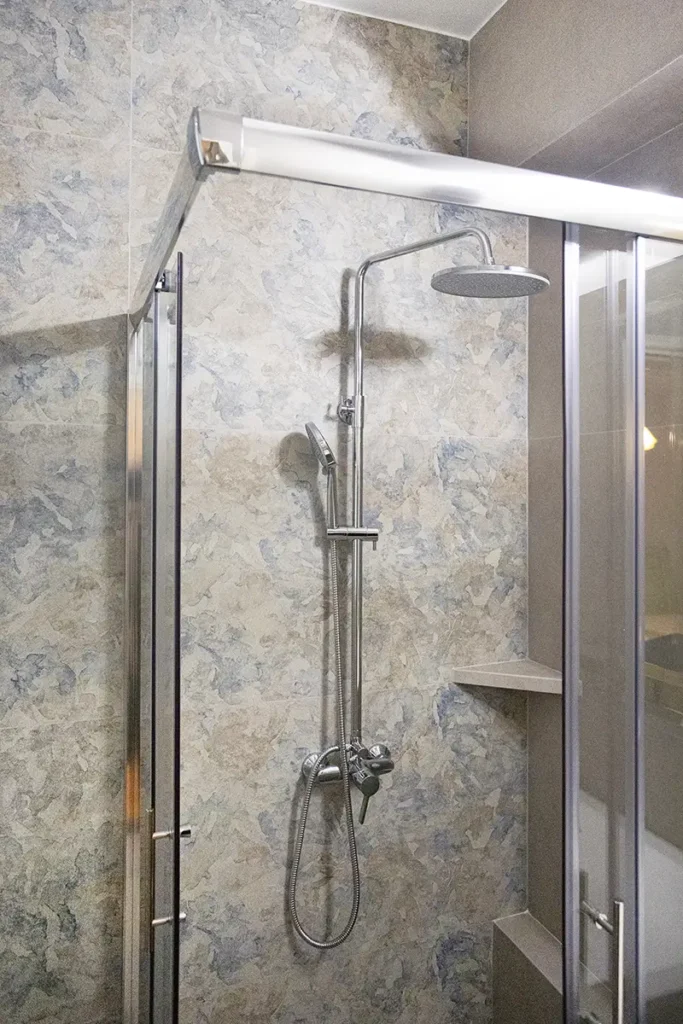 Ντουζιέρα σε ανακαινισμένο μπάνιο στη Γλυφάδα με ιδιαίτερο πλακάκι τοίχου